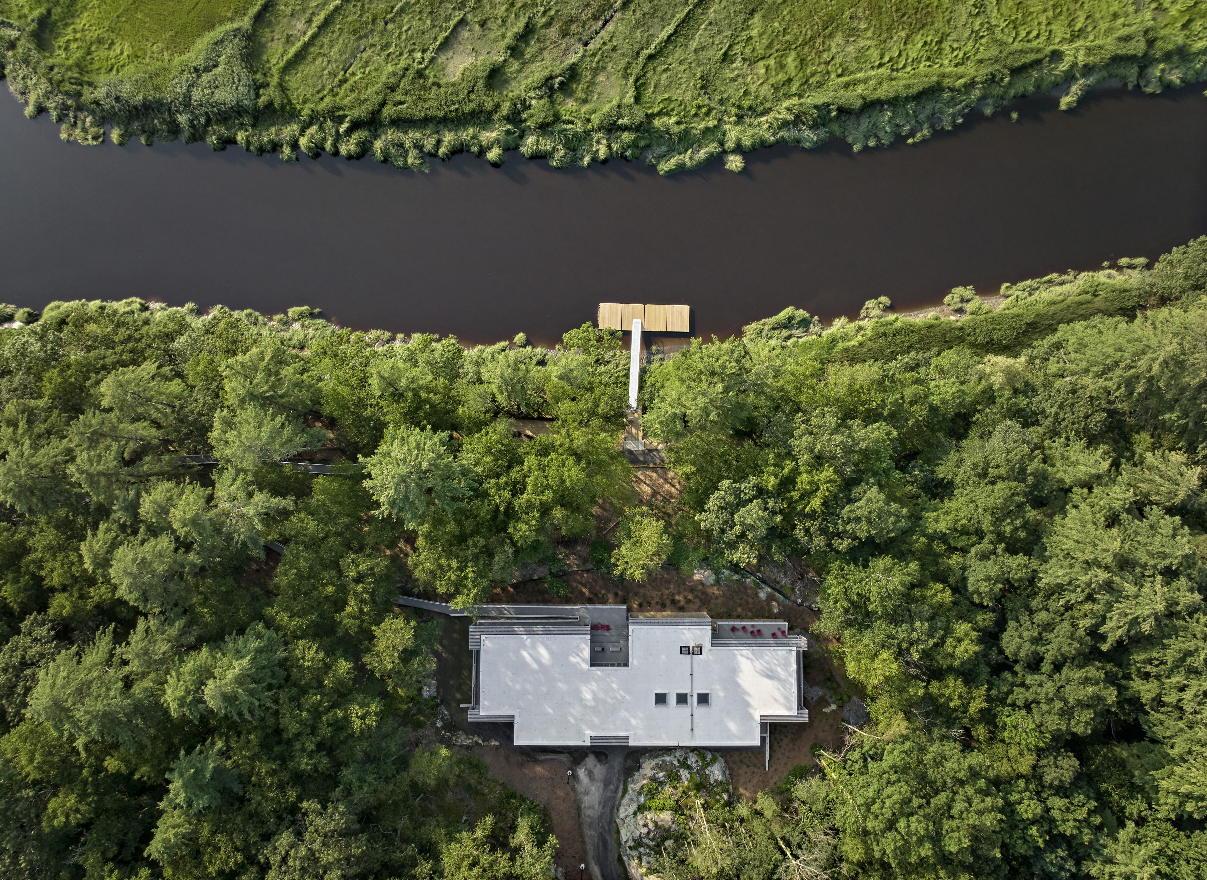 Aerial view of center next to river and surrounded by greenery