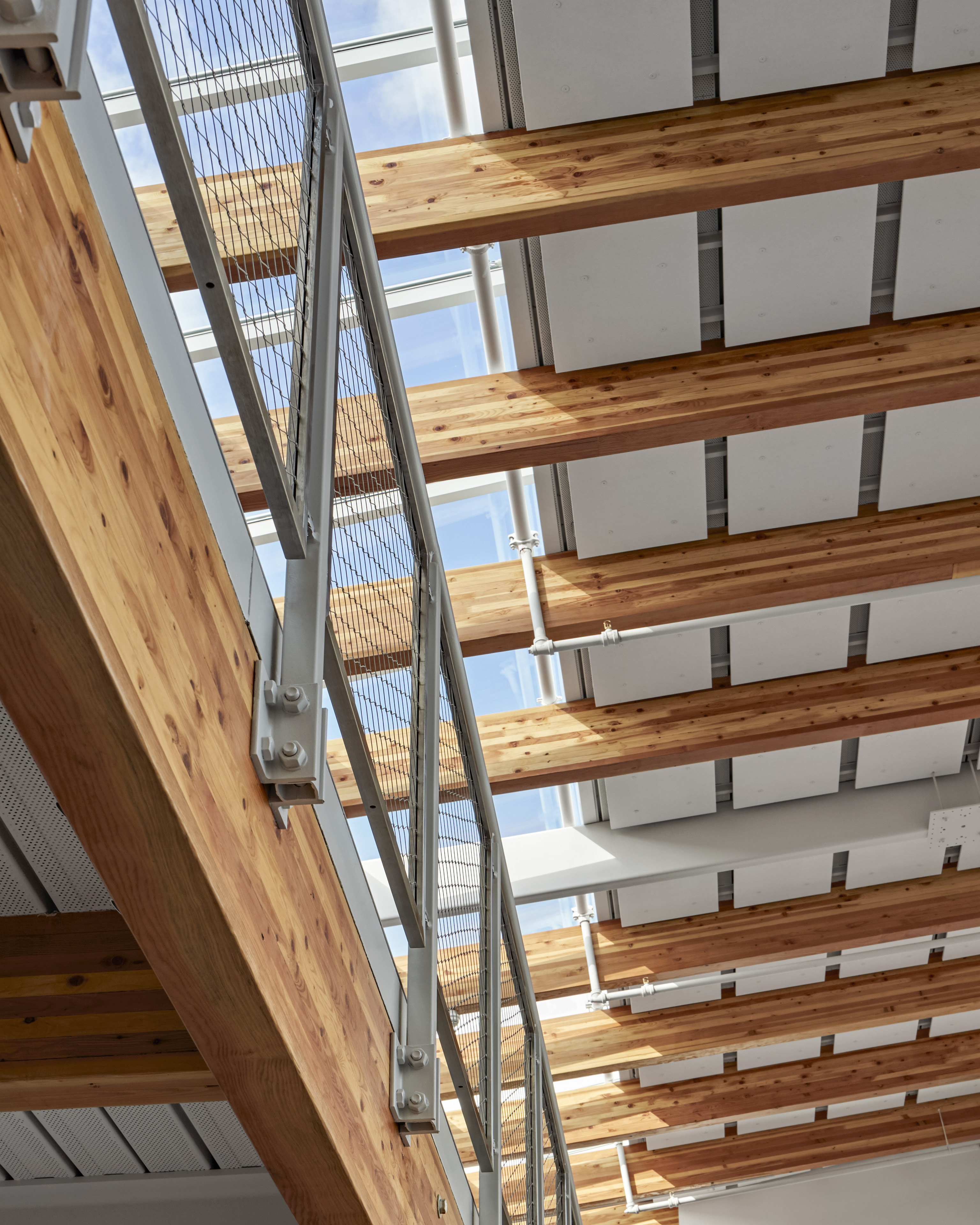 View of ceiling with large natural wood beams and windows on the left