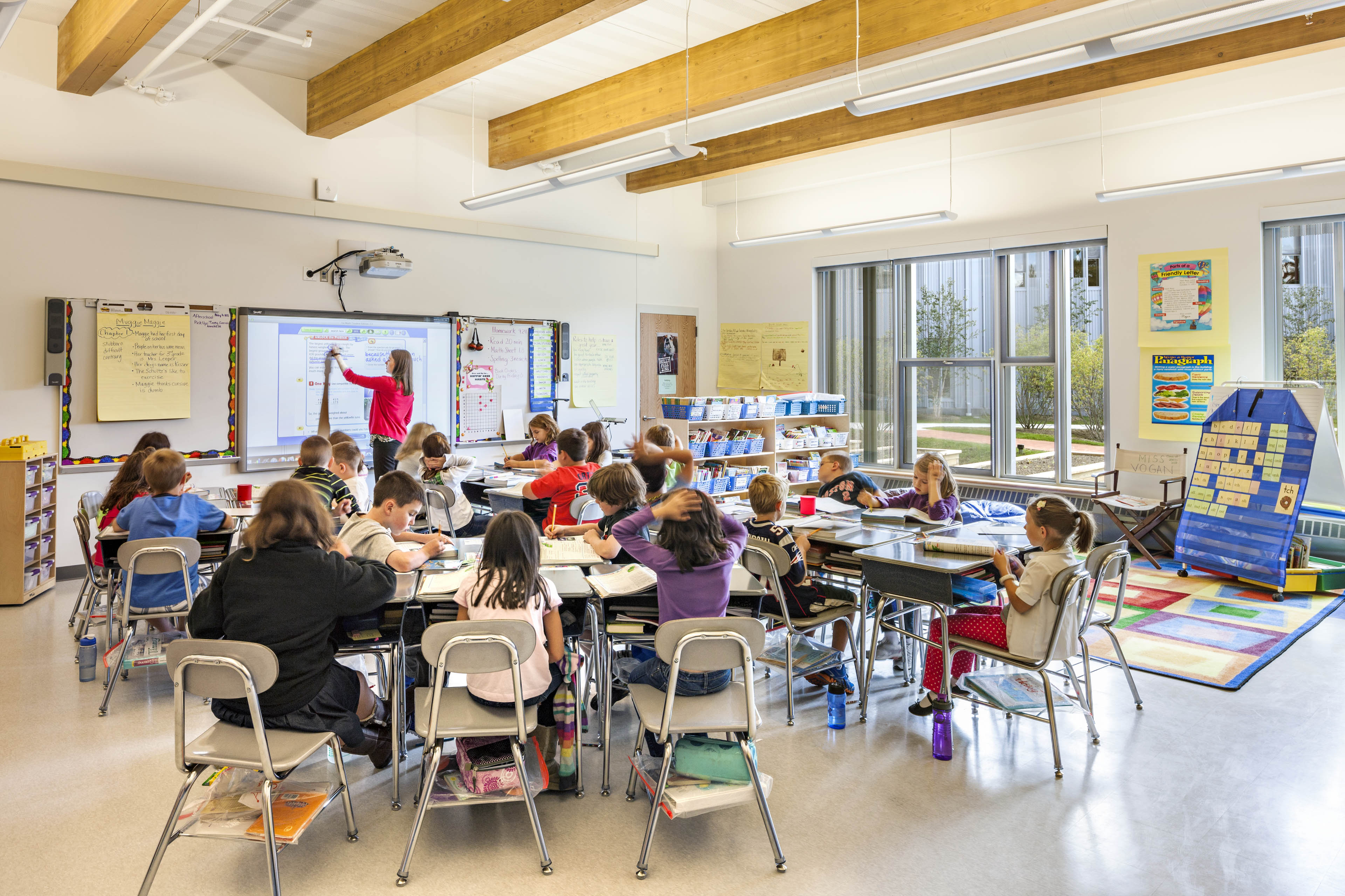 Students and teachers in classroom at desks
