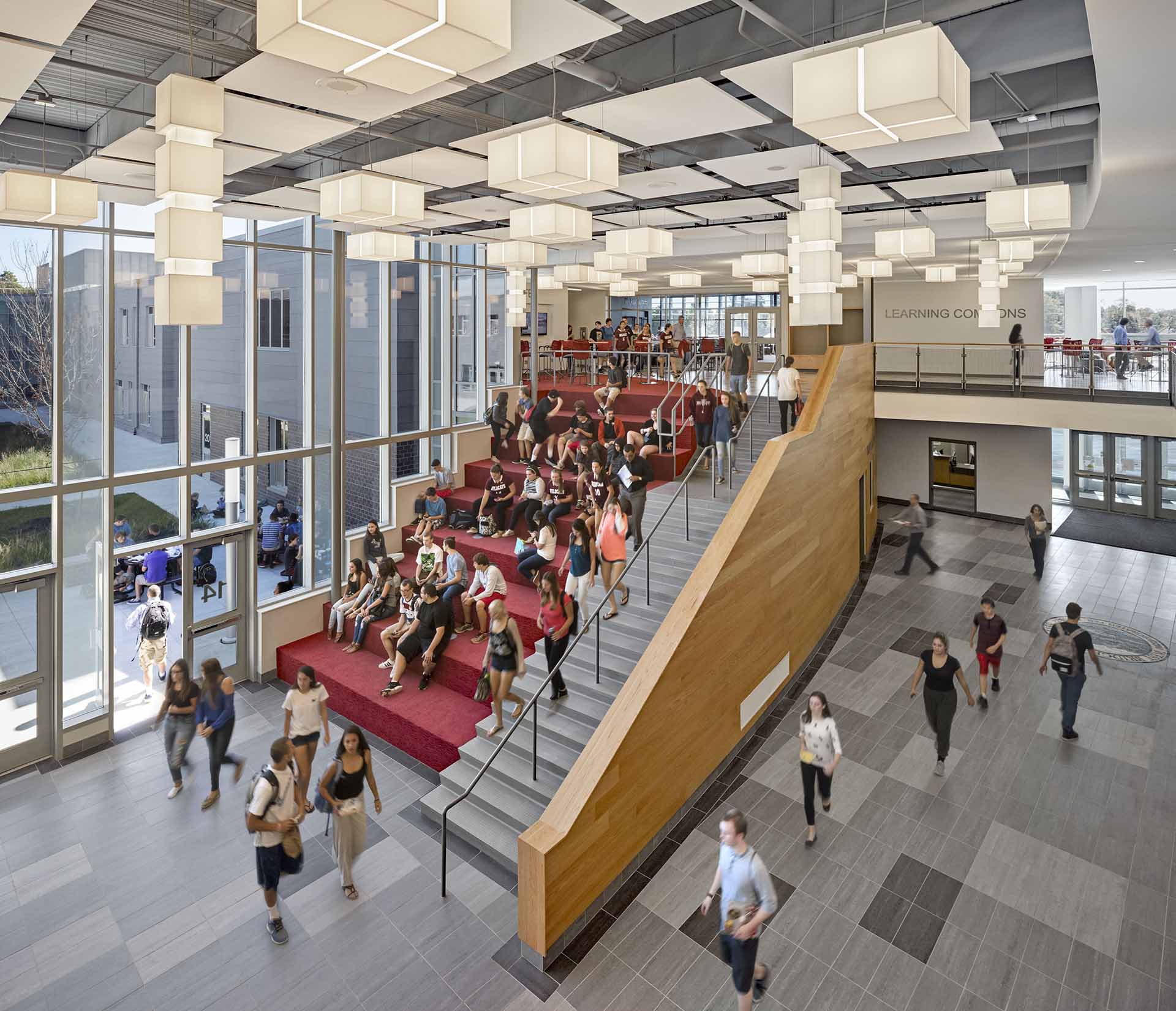 Students seated at large red cafeteria steps