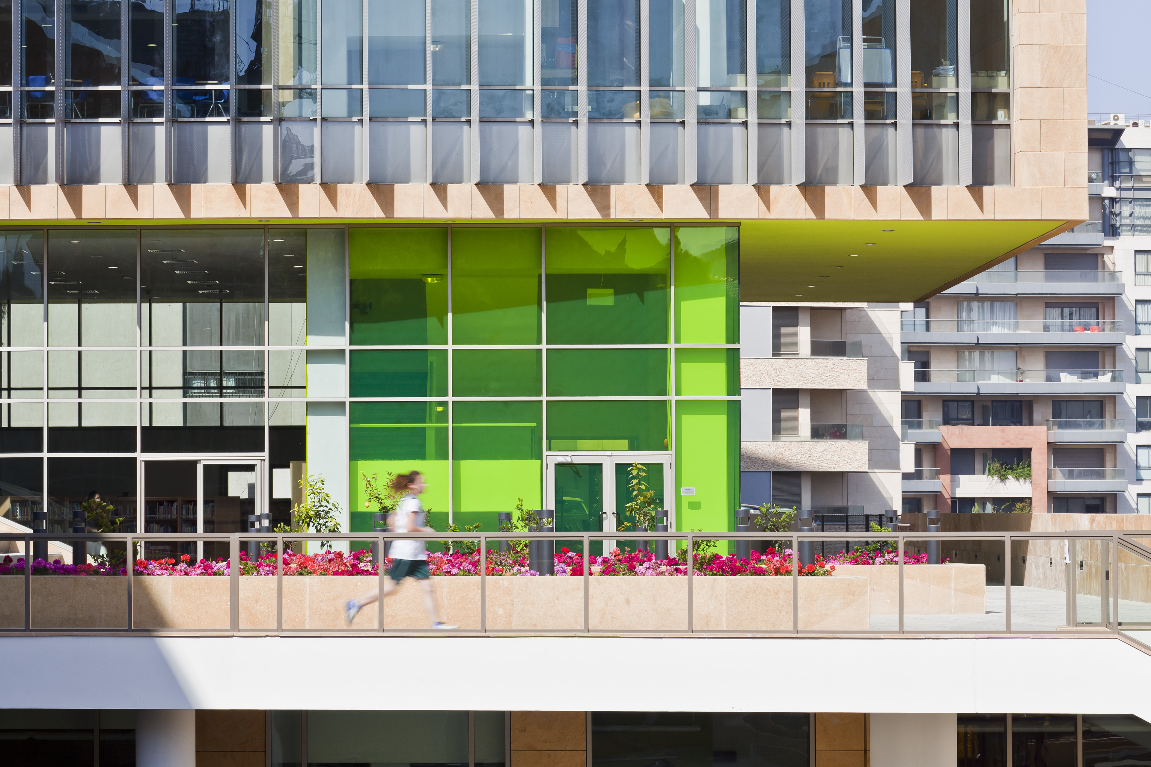 View from exterior looking at green window area with balcony in front