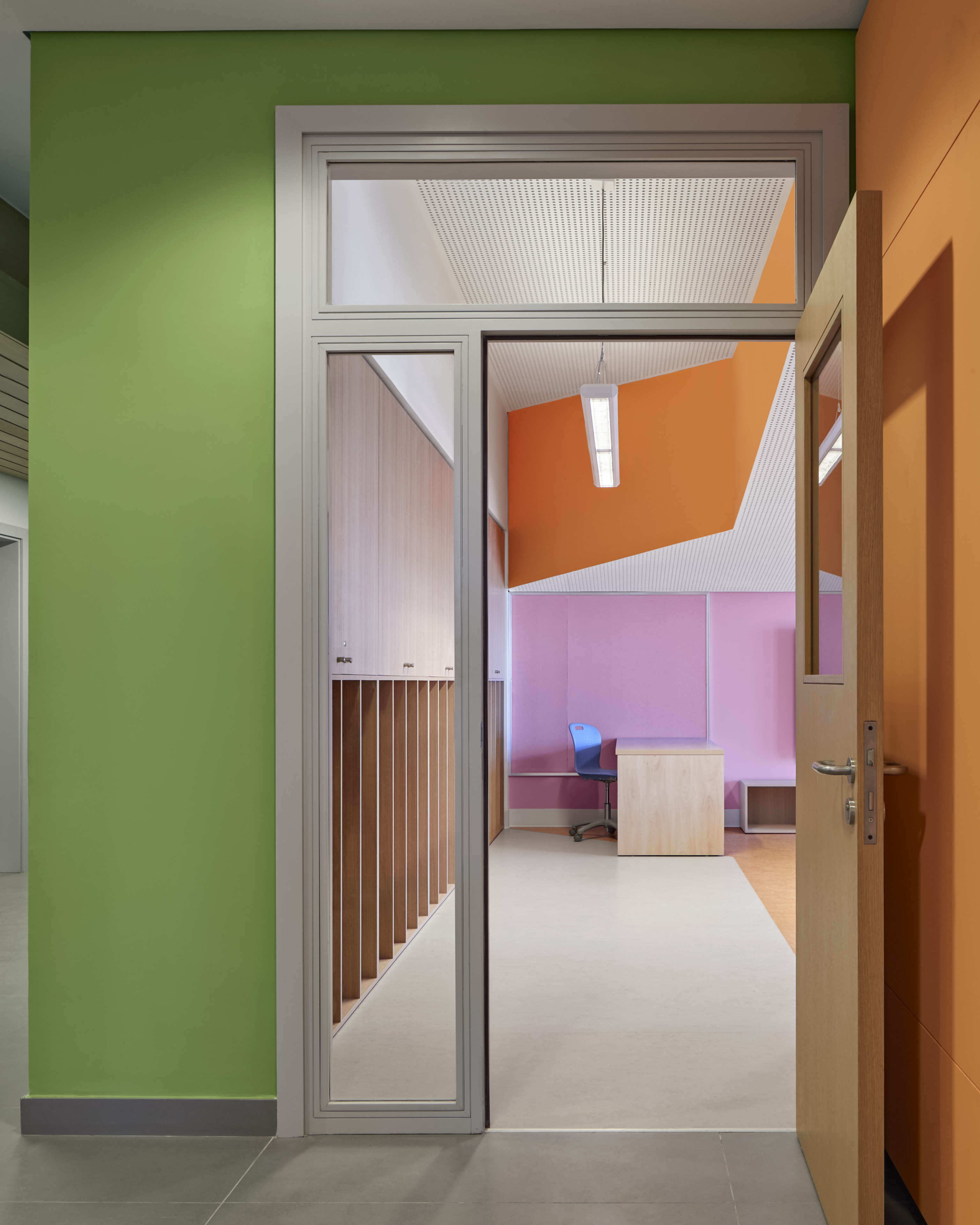 Door to classroom with green wall on the outside and pink and orange accents on wall in background