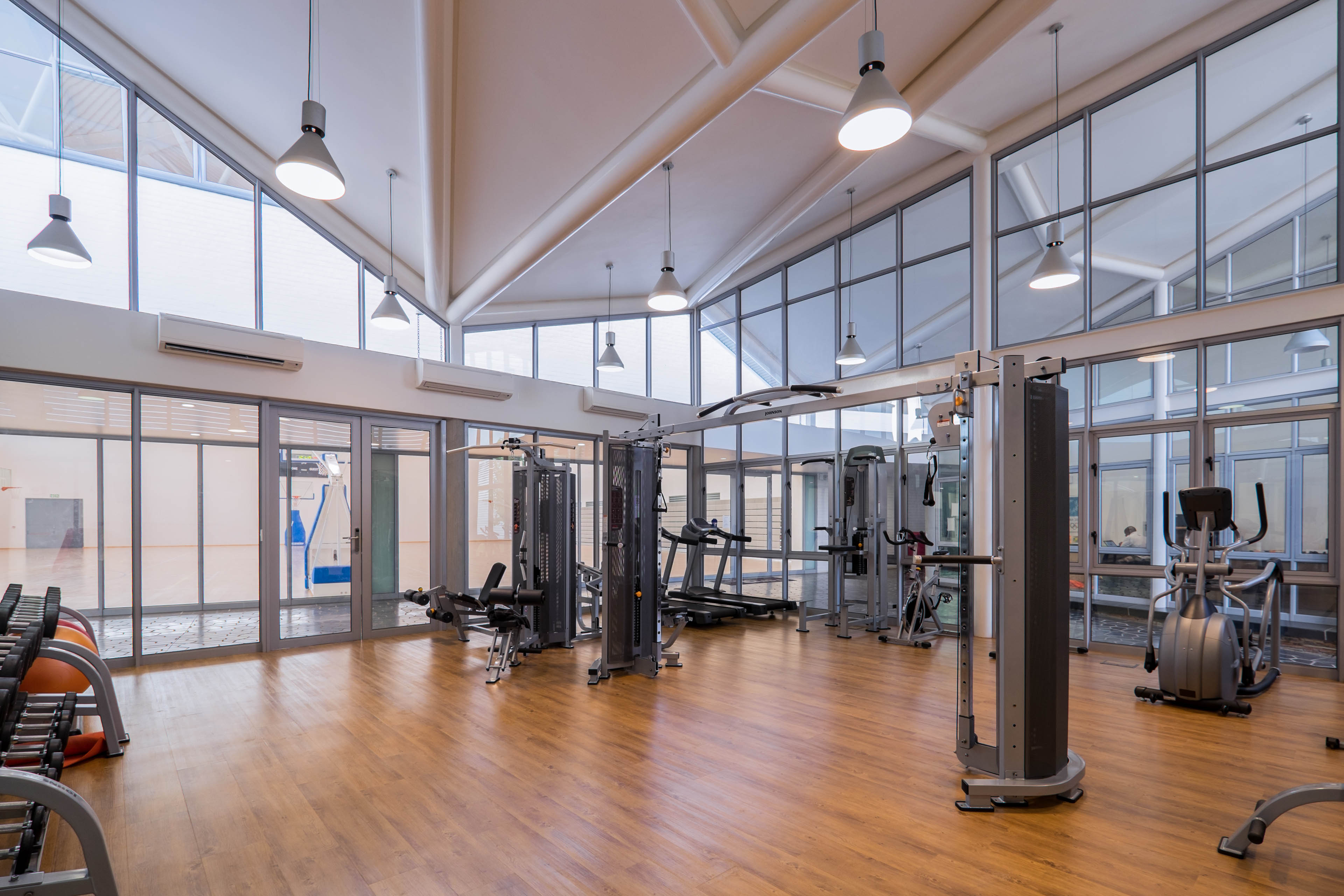 Weight room with machines and windows all around allowing natural light