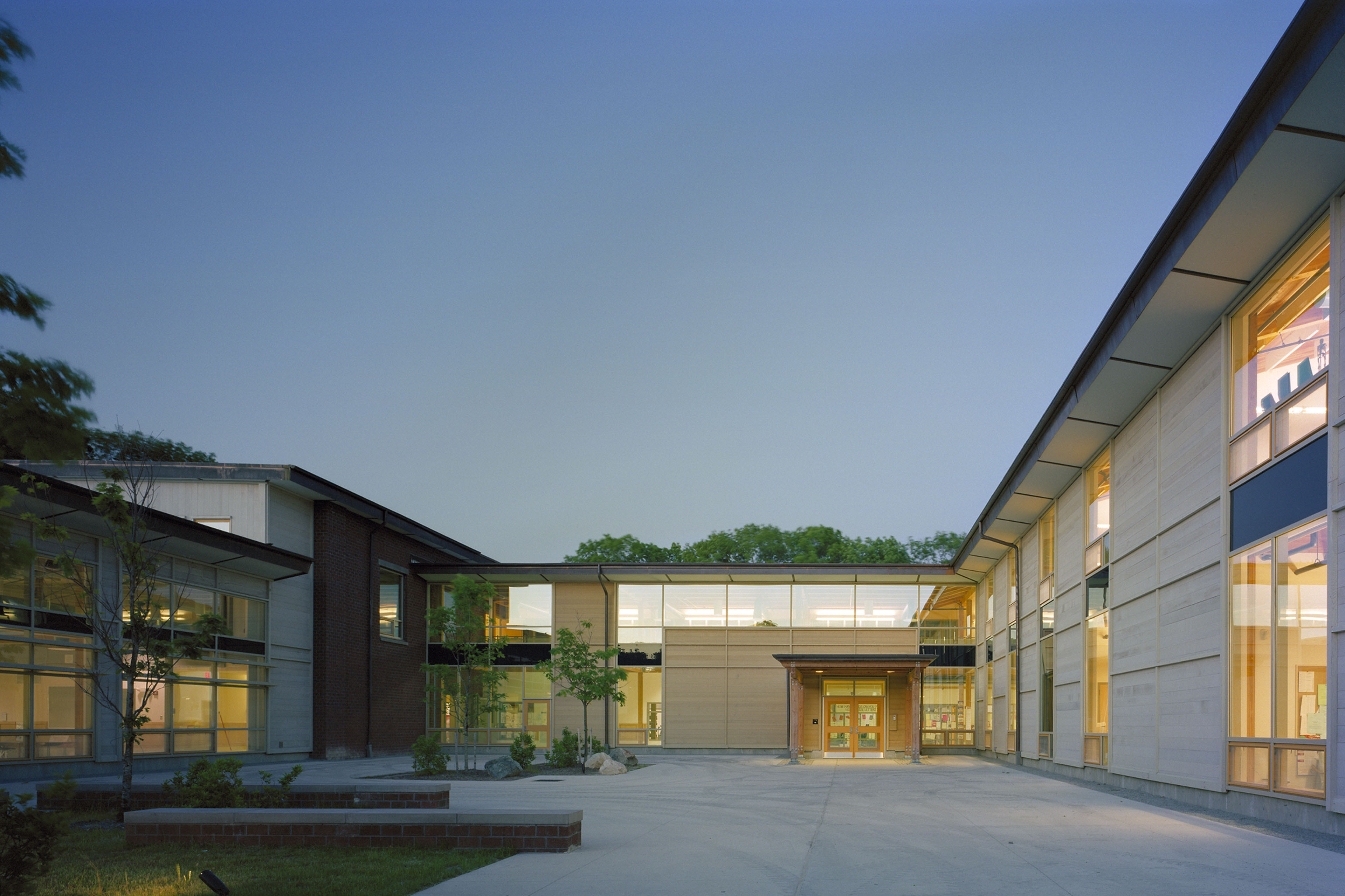 Courtyard at dusk with yellow light emitting from building