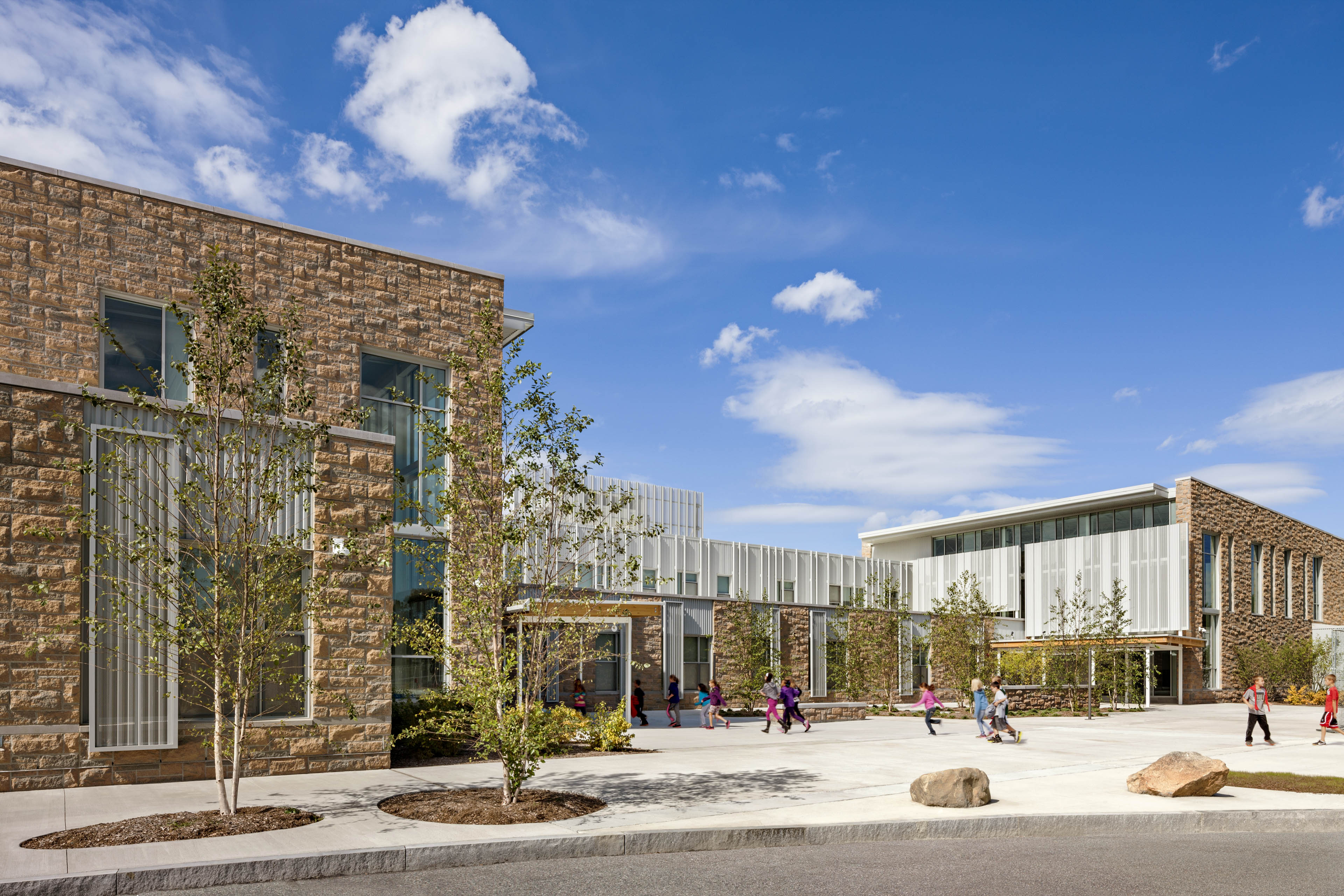 Students walking into entrance of school with blue sky behind