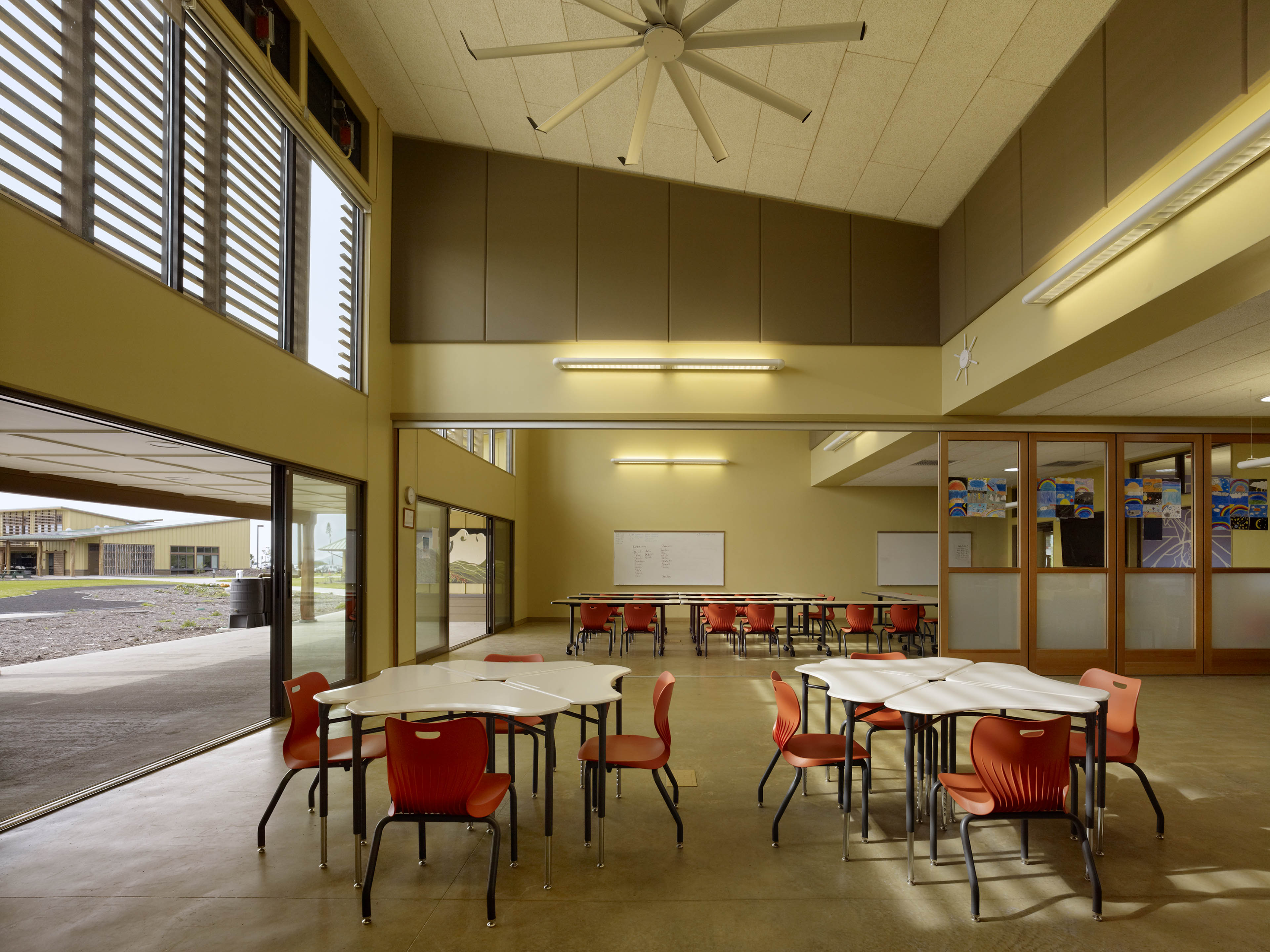 Classroom with clustered seats and open entrance to the left looking out to field