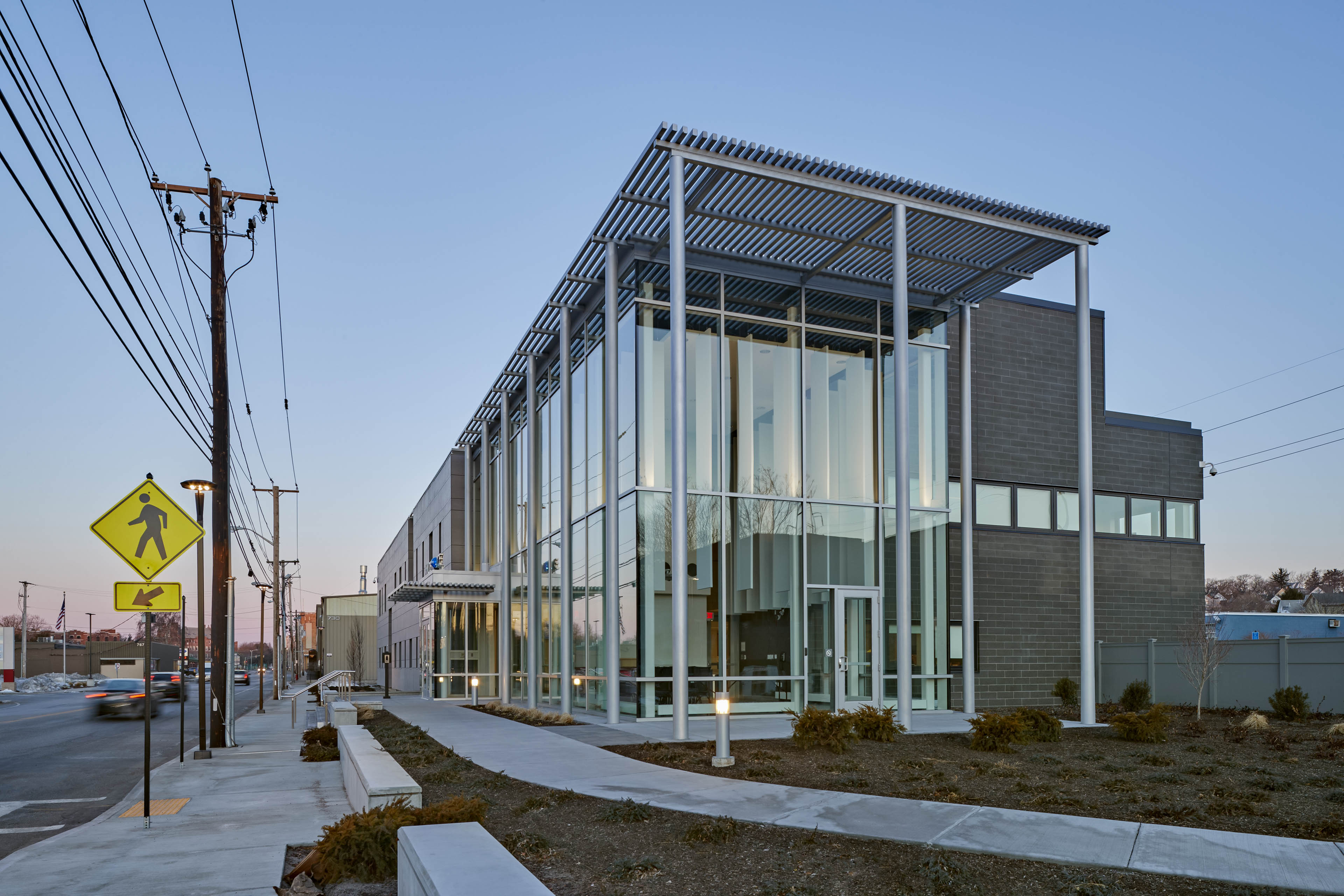 Side angle view of entrance of building with sunrise behind with street to the left