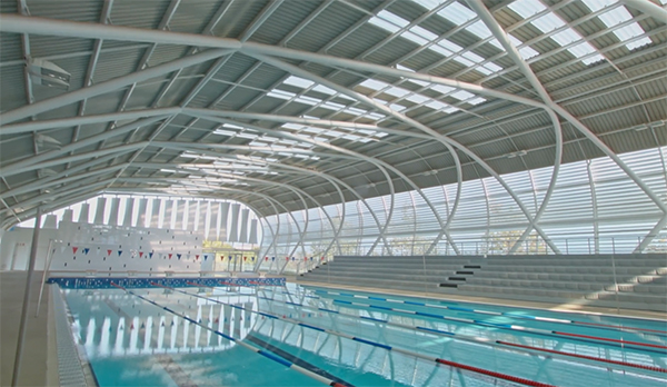 Indoor pool with lane lines and ample sunlight