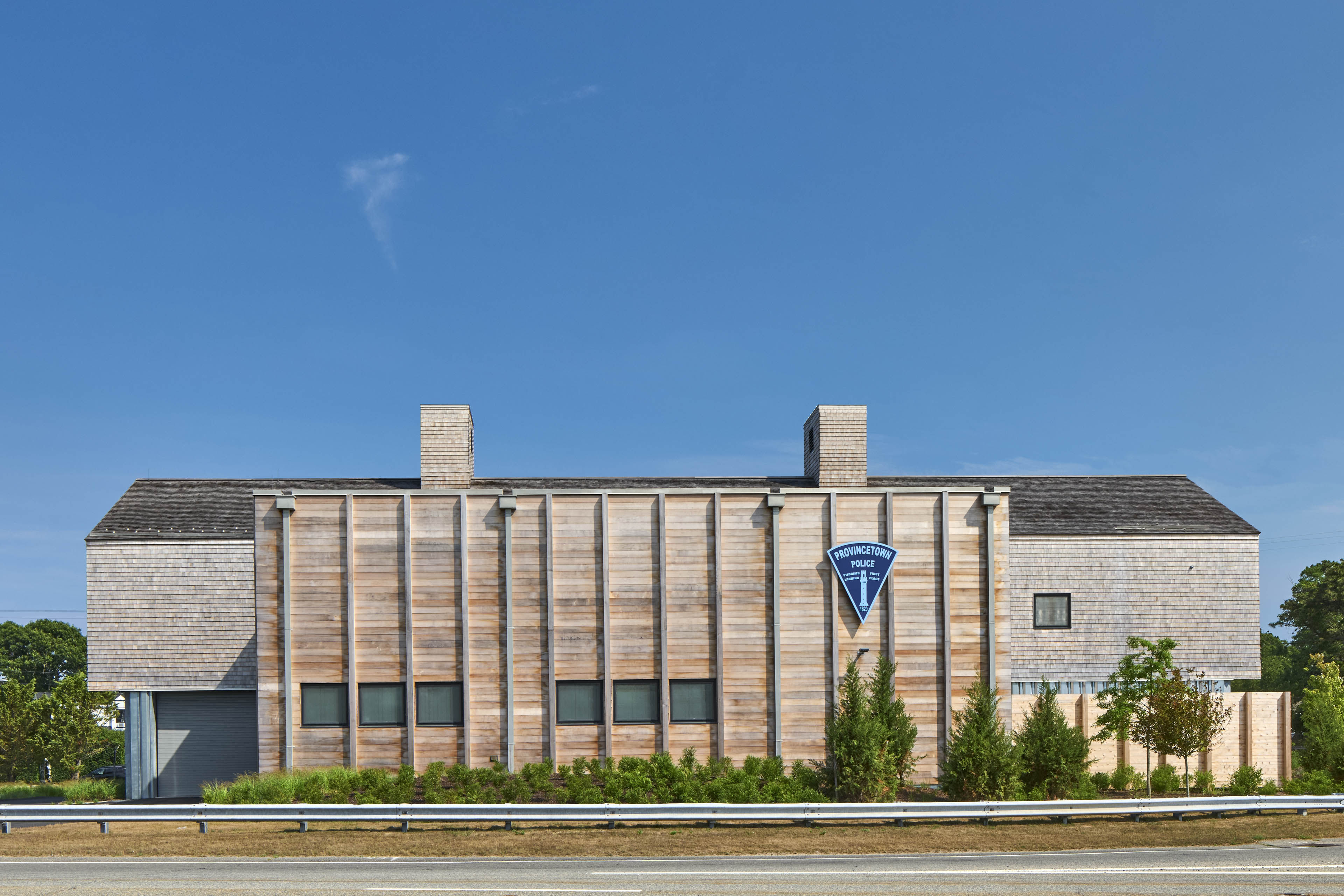 Street view of exterior of building with sign in an upside down blue triangle to the right and blue sky behind