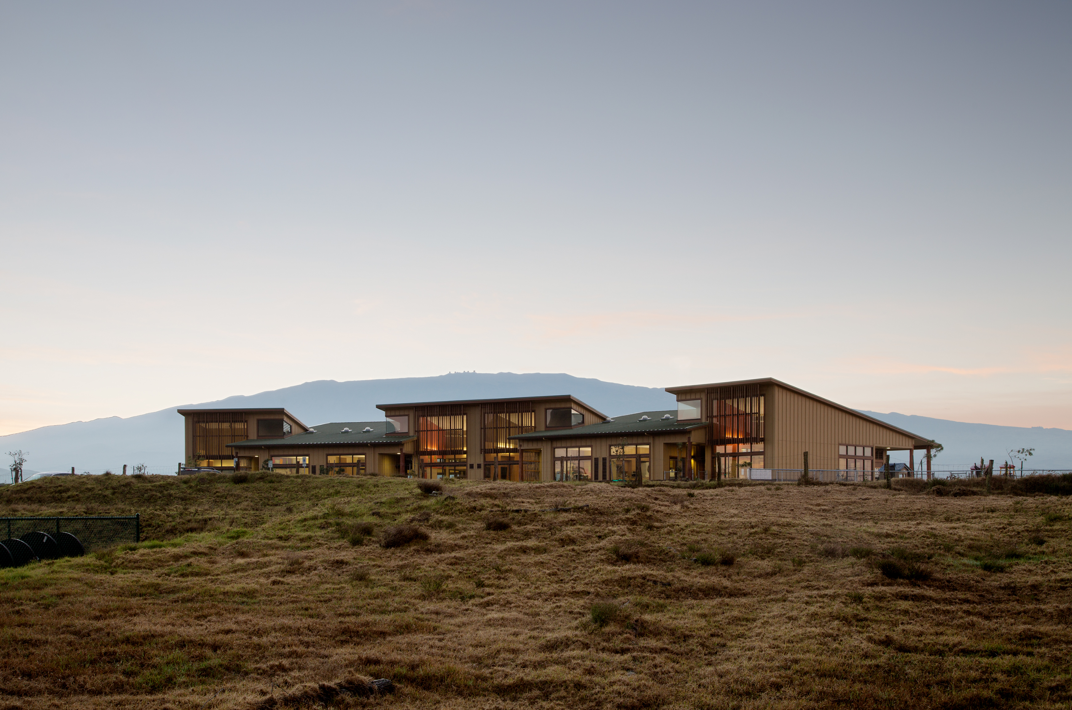 View of School from field below with mountains in sunset behind