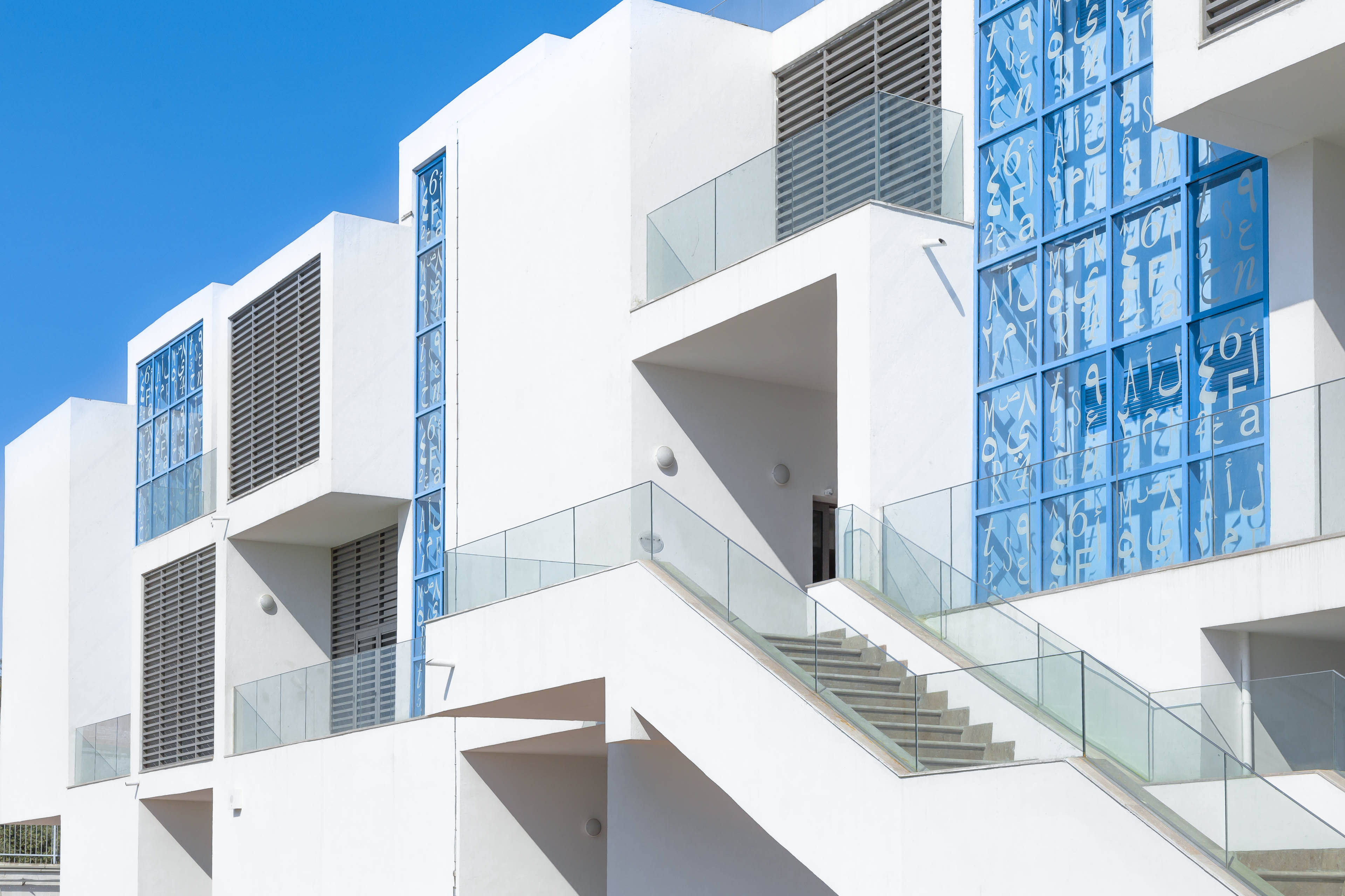 Side angle of white building with light blue windows 