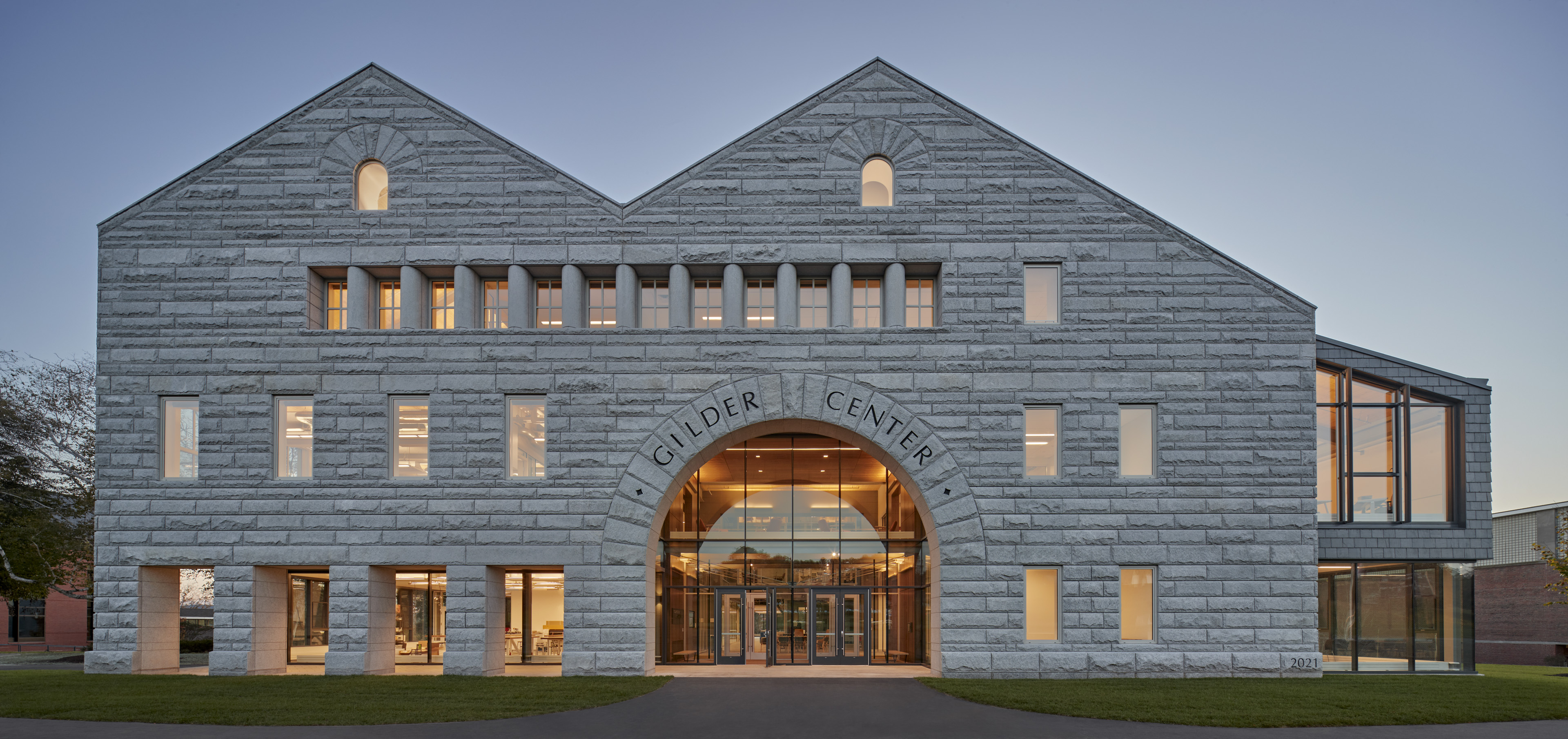 Front of Gilder Center with large arch entrance, vertical windows to left and right, columns at top around window panes, 2 arch windows under each roof peak