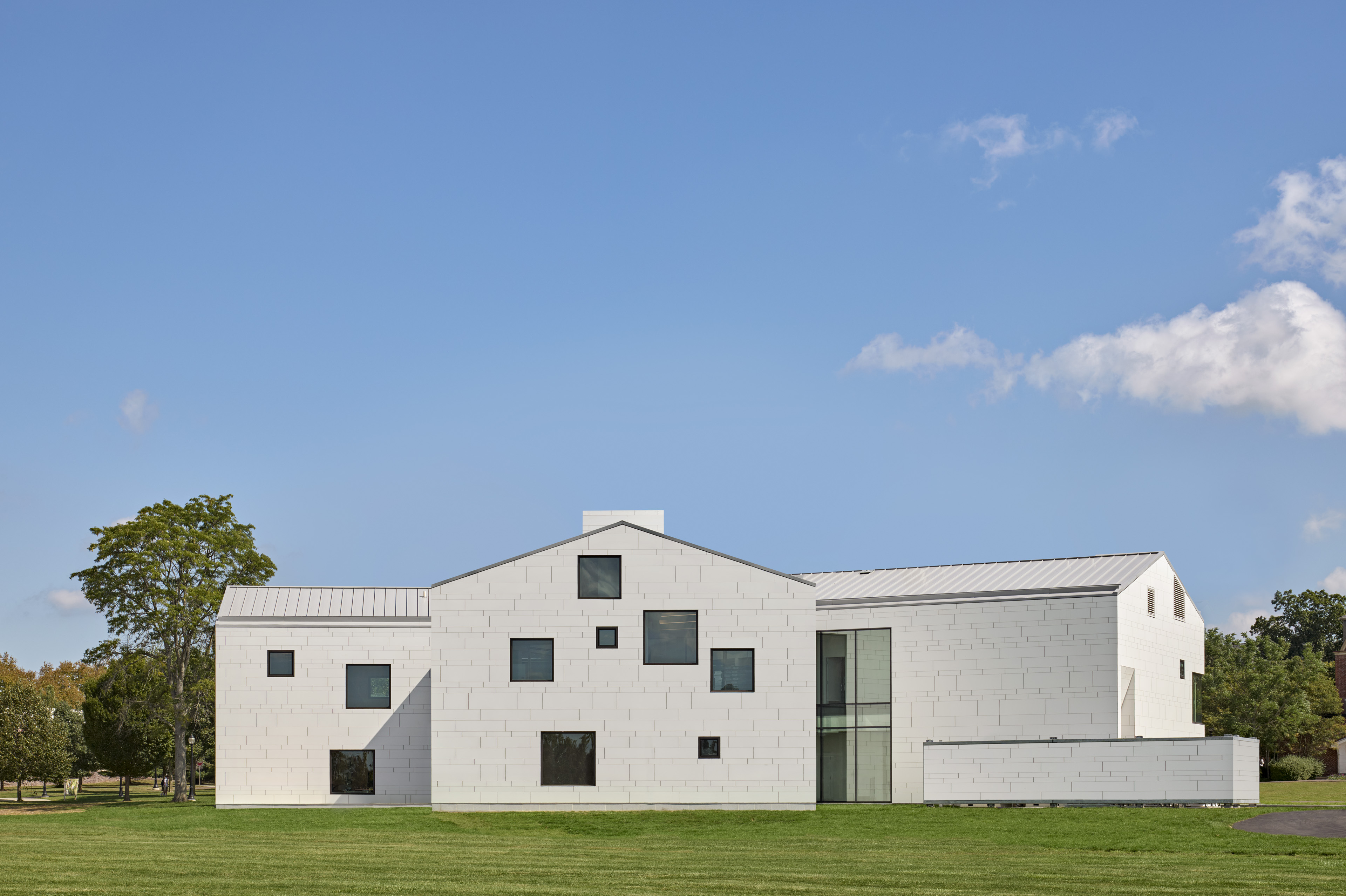 Exterior of student center with barn like structure situated on green grass with blue sky behind