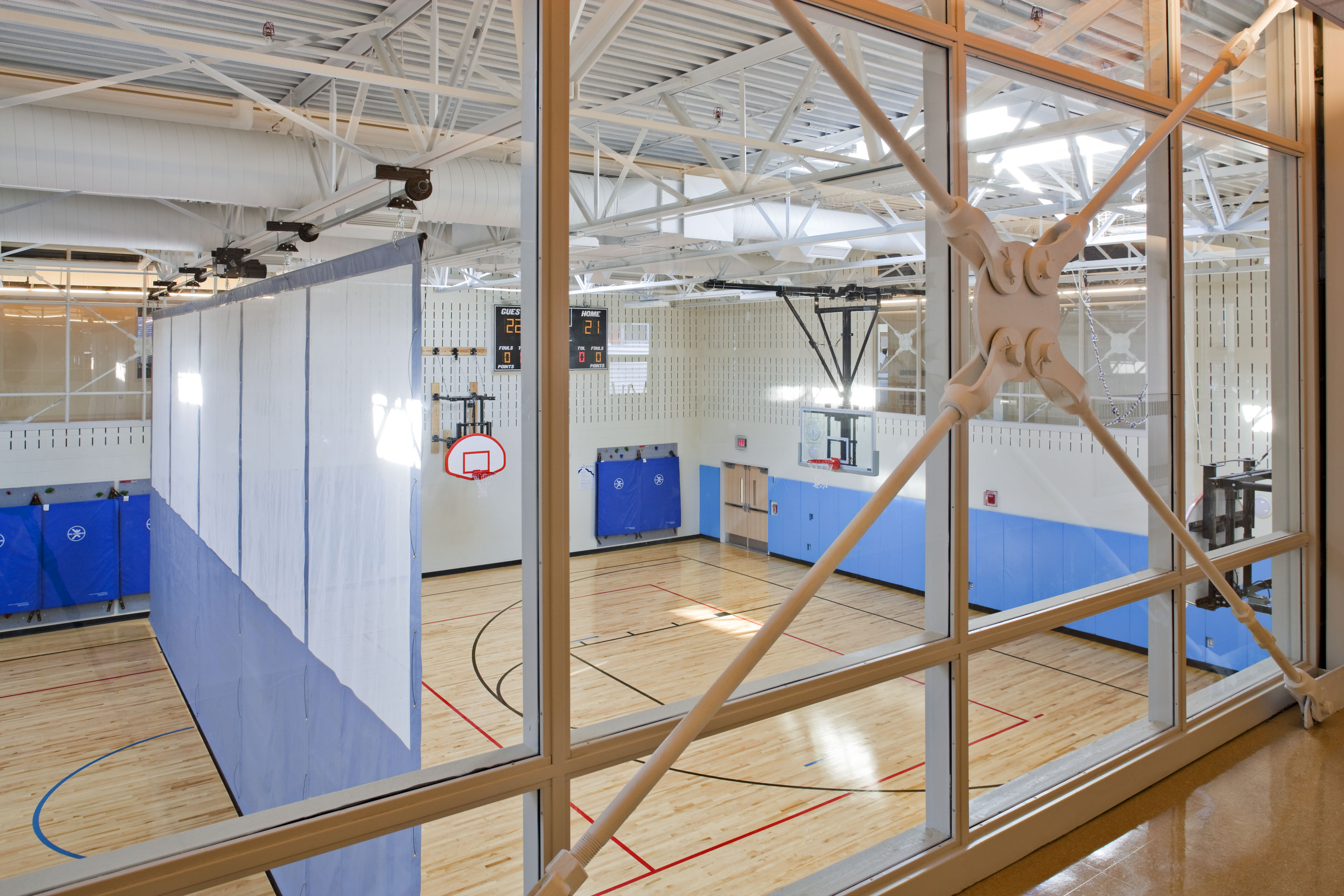 View of gymnasium from second floor, basketball courts with temporary divider down the middle
