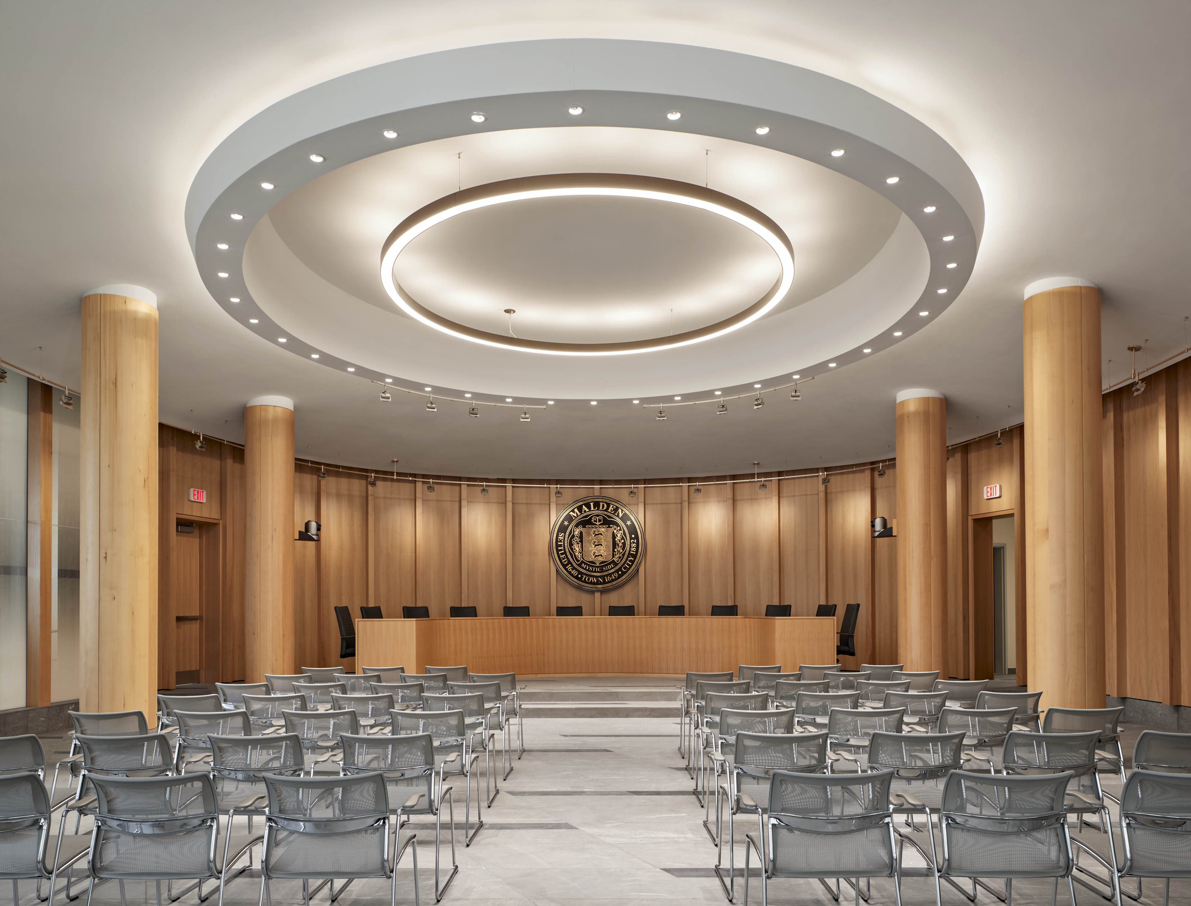 Meeting room with large wood poles on left and right and seats in center