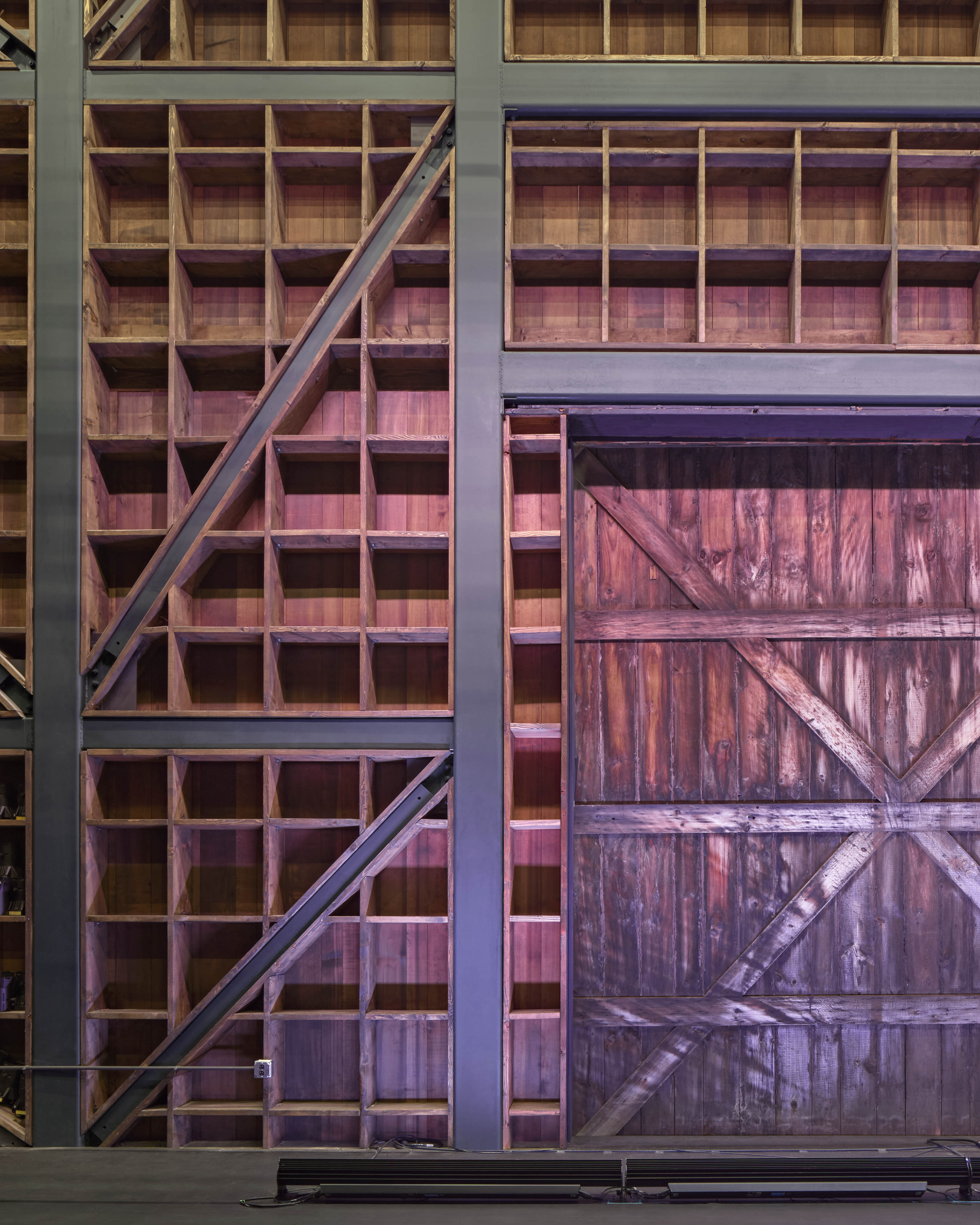 Interior wood in small square formation with barn door to the right and pink lighting displayed across