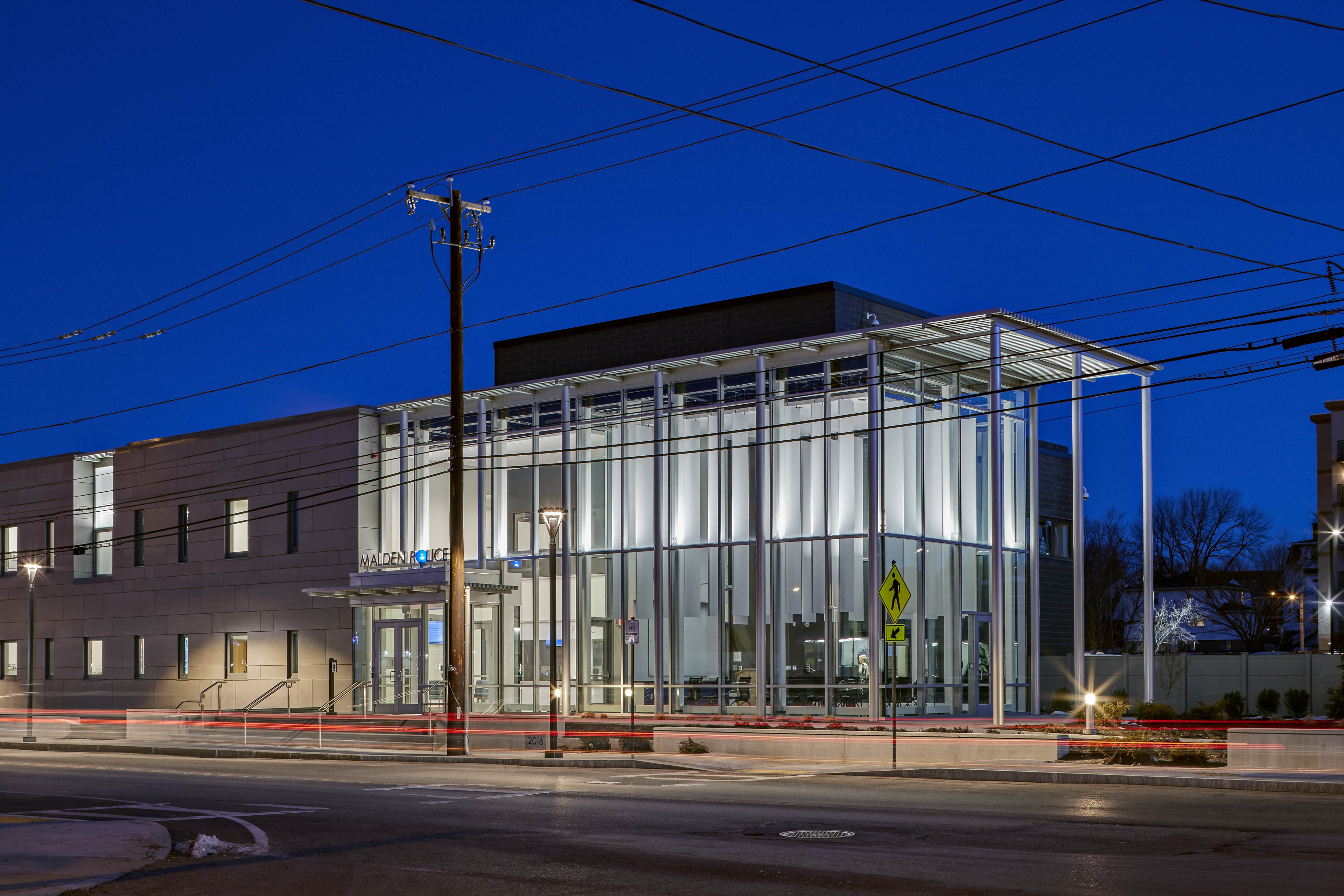 Side view from street at dawn, right side of building has floor to ceiling windows