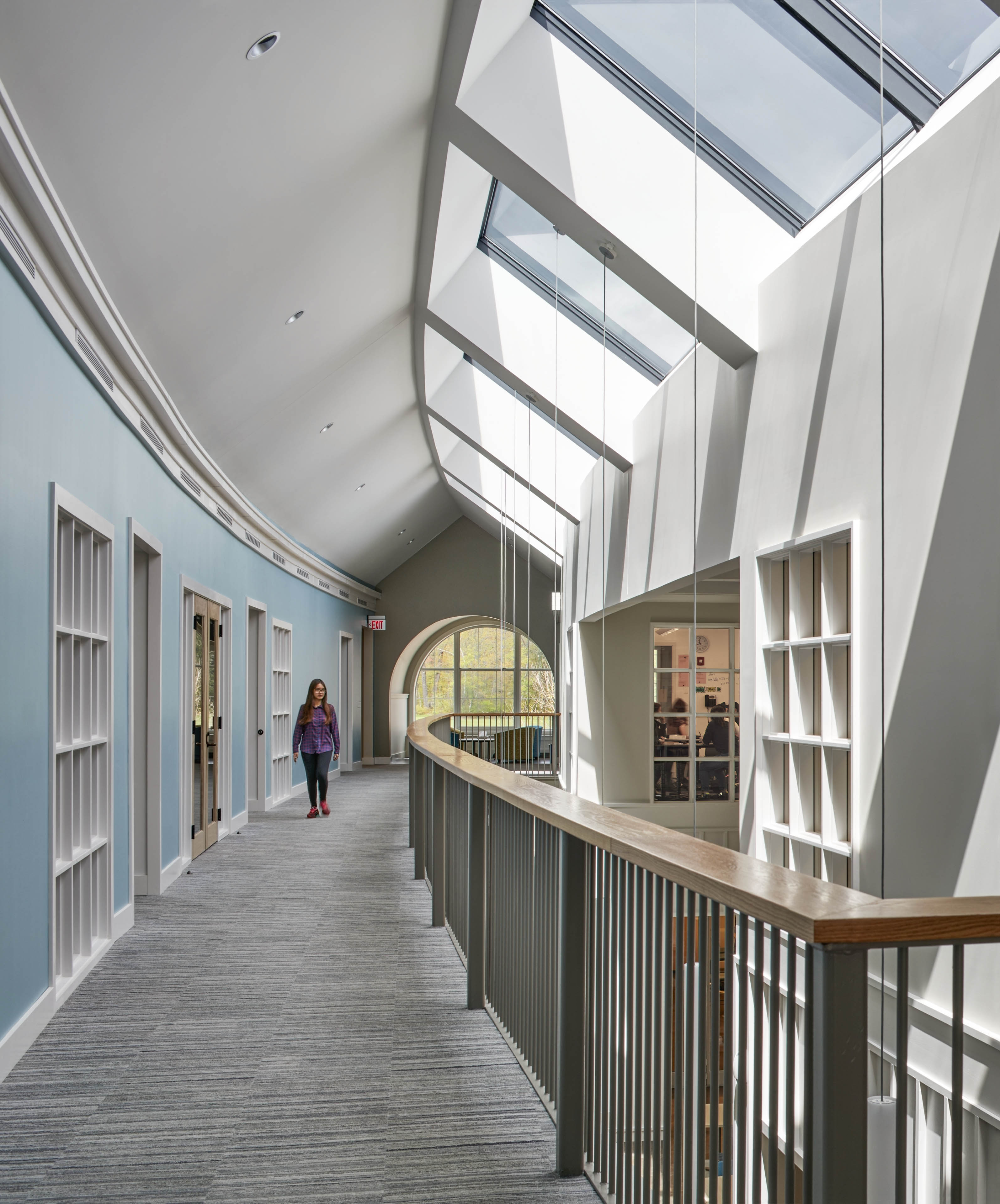 Interior corridor with blue wall to the left and railing to the right