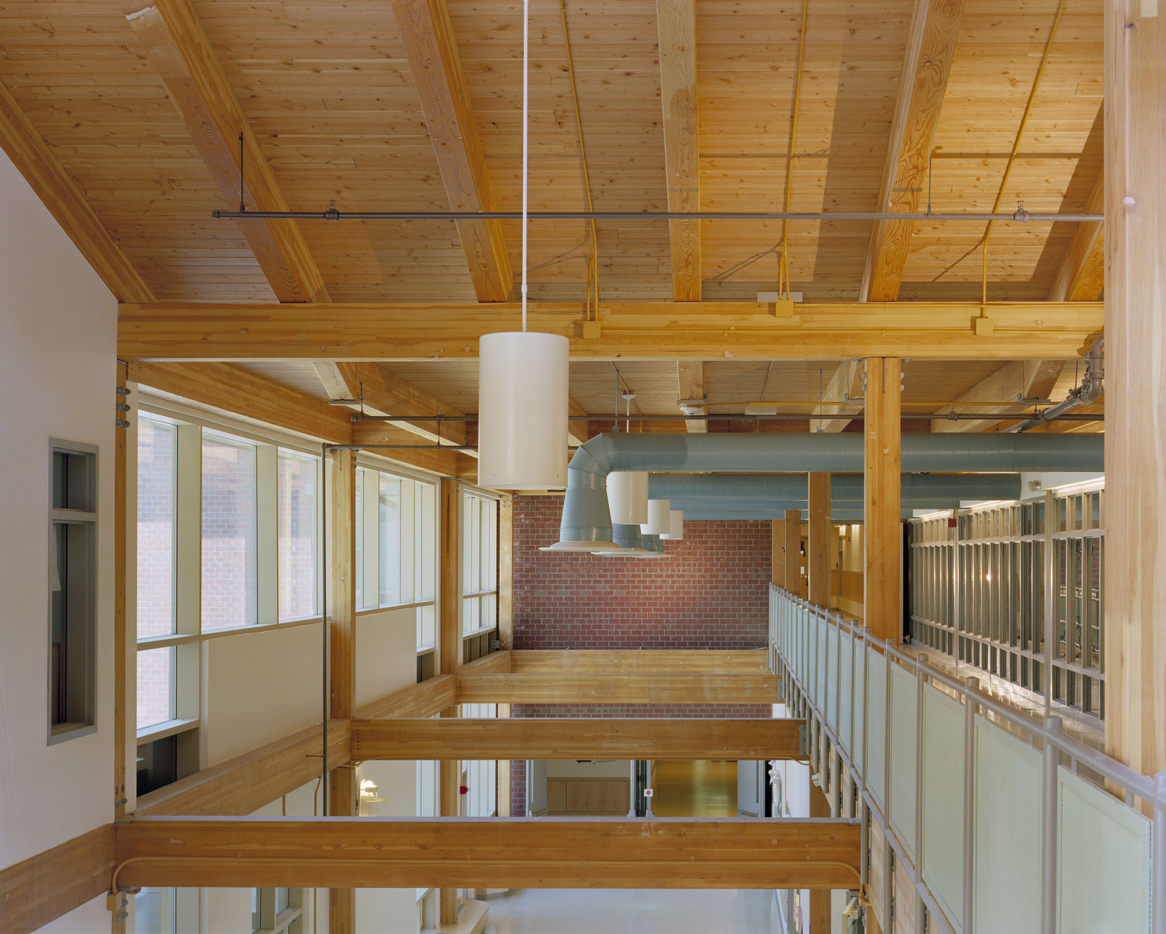 Upper floor ceiling with large wood beams and hanging lights