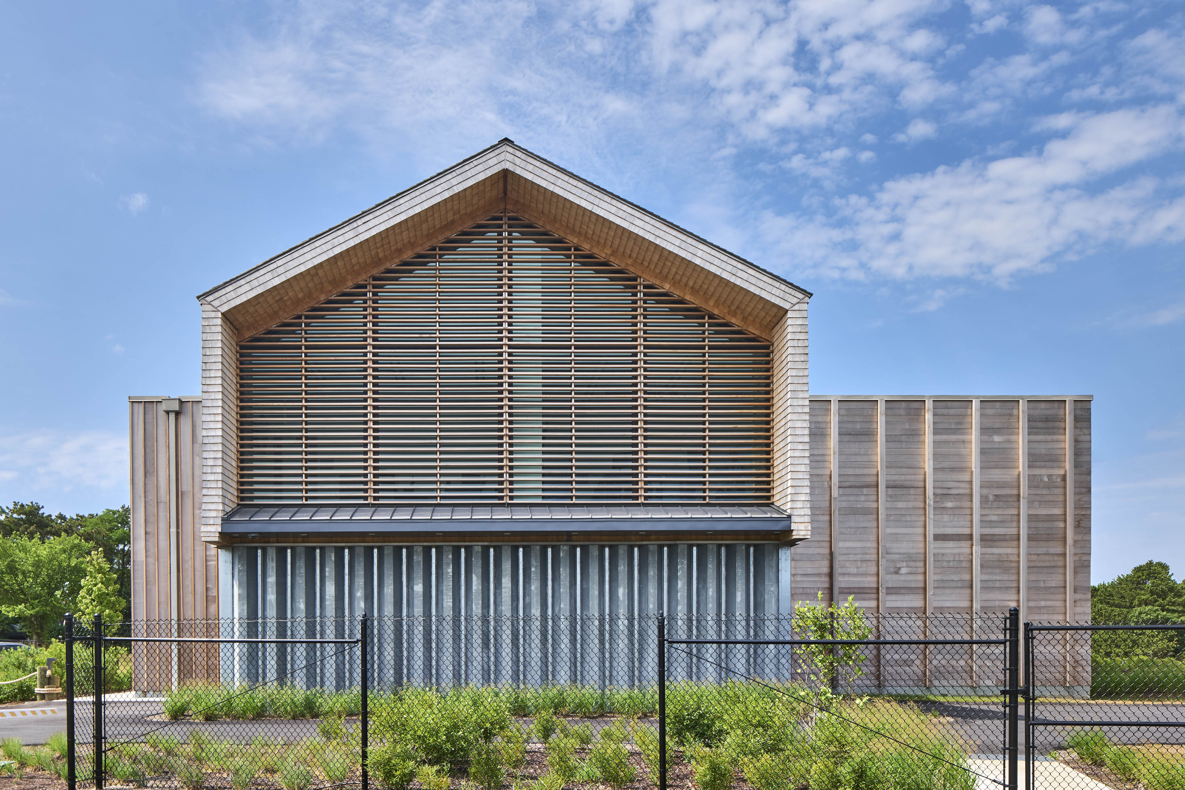 Exterior of building at with slats on the second floor and blue sky behind