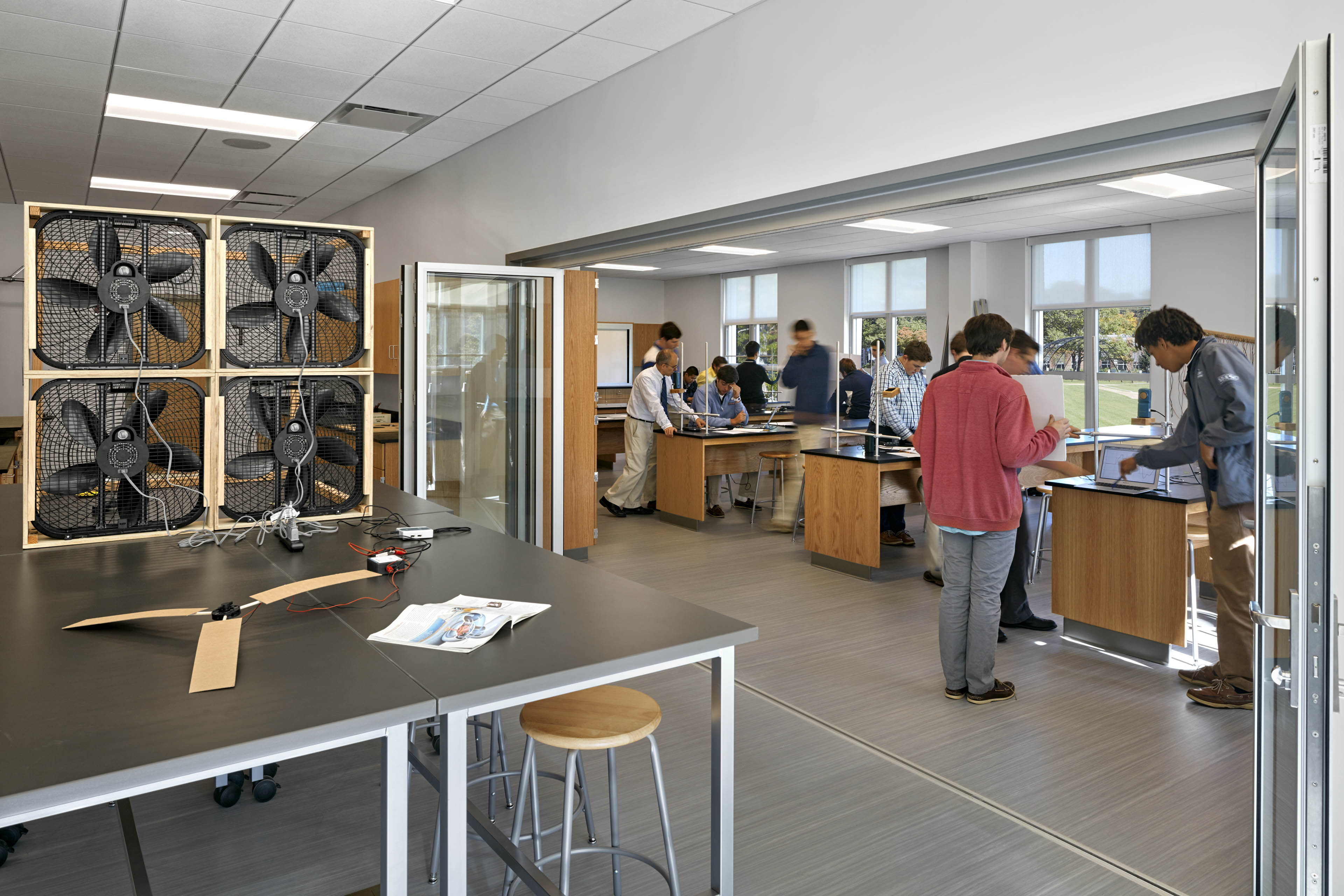 Students in science lab on right side and large fans on left side