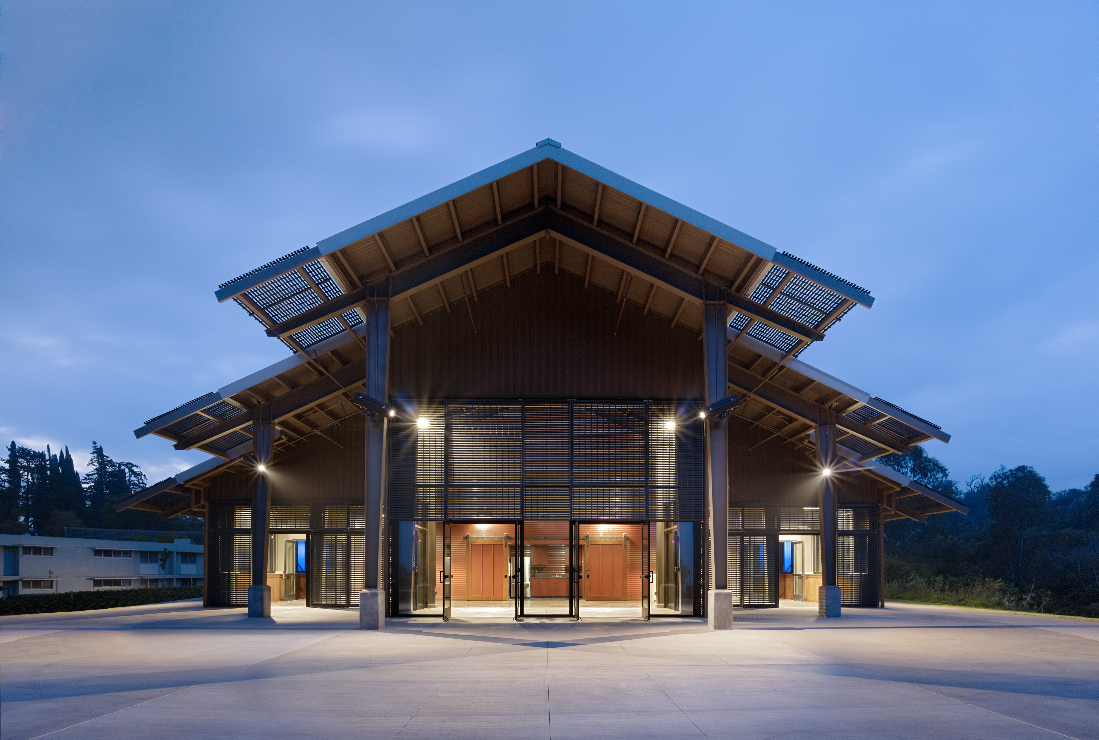 Exterior of entrance at dusk with tiered roofing and ambient lighting