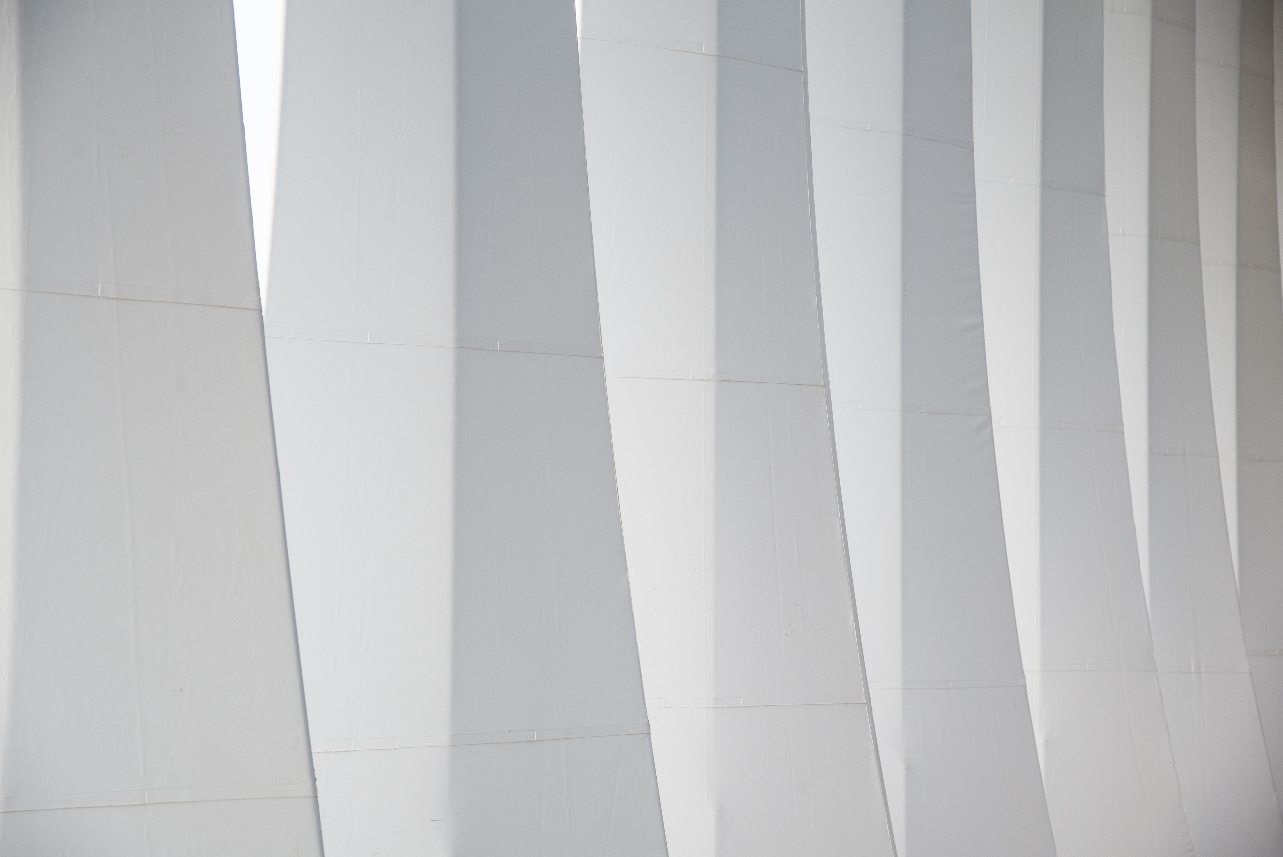 White triangular structures letting light in at top of building wall
