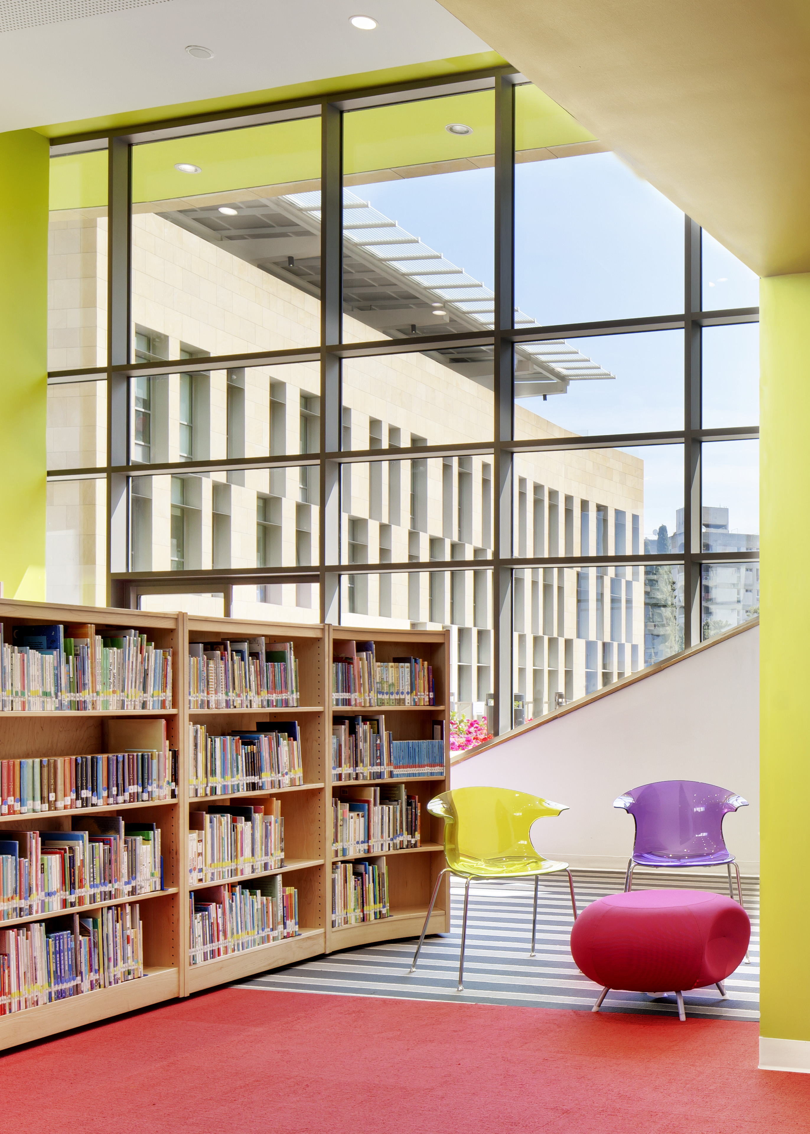 Library with red carpet and book shelves to the left, windows behind with green paint around