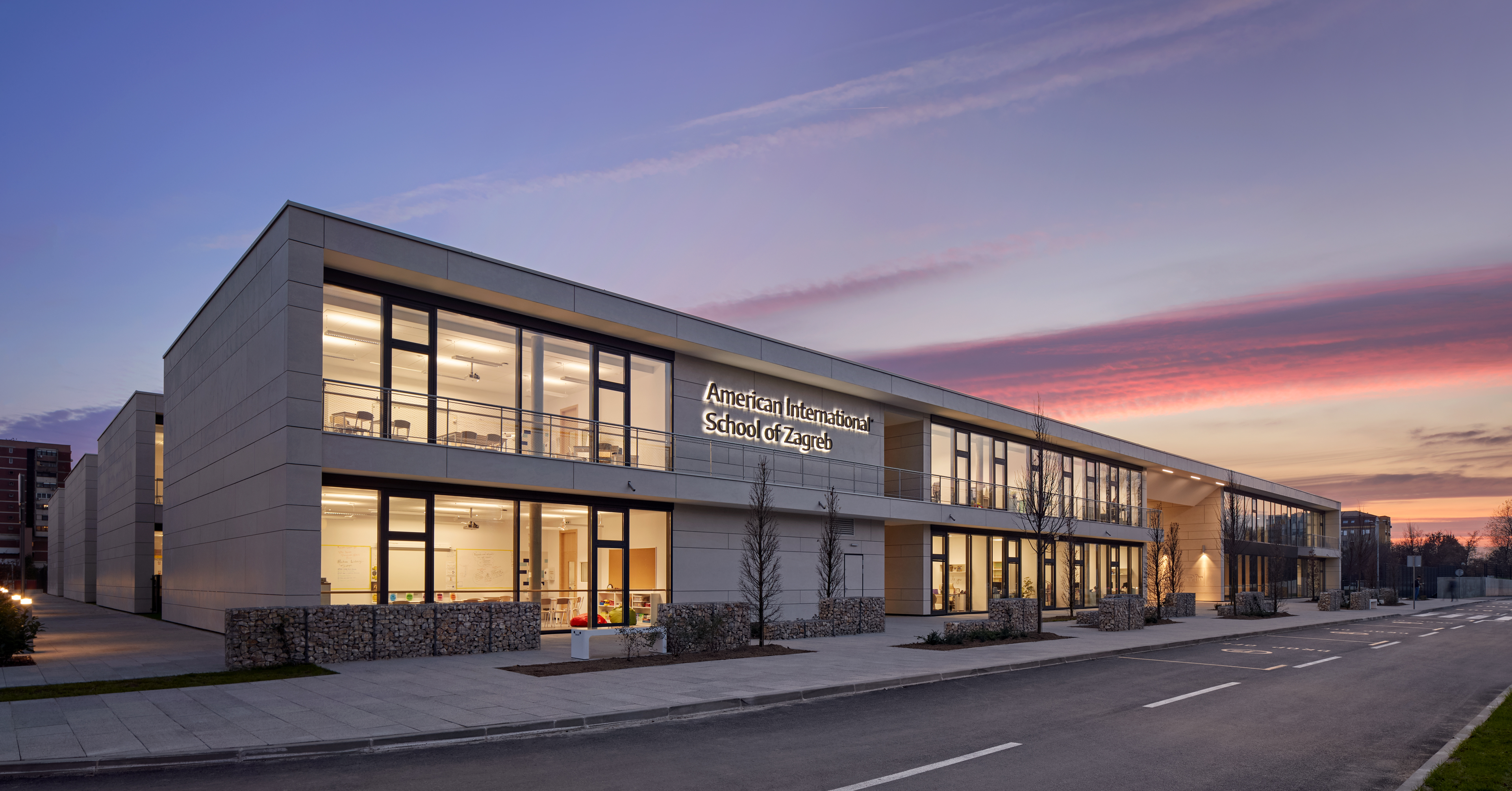 Front exterior of AISZ with purple/pink sunset streaking behind