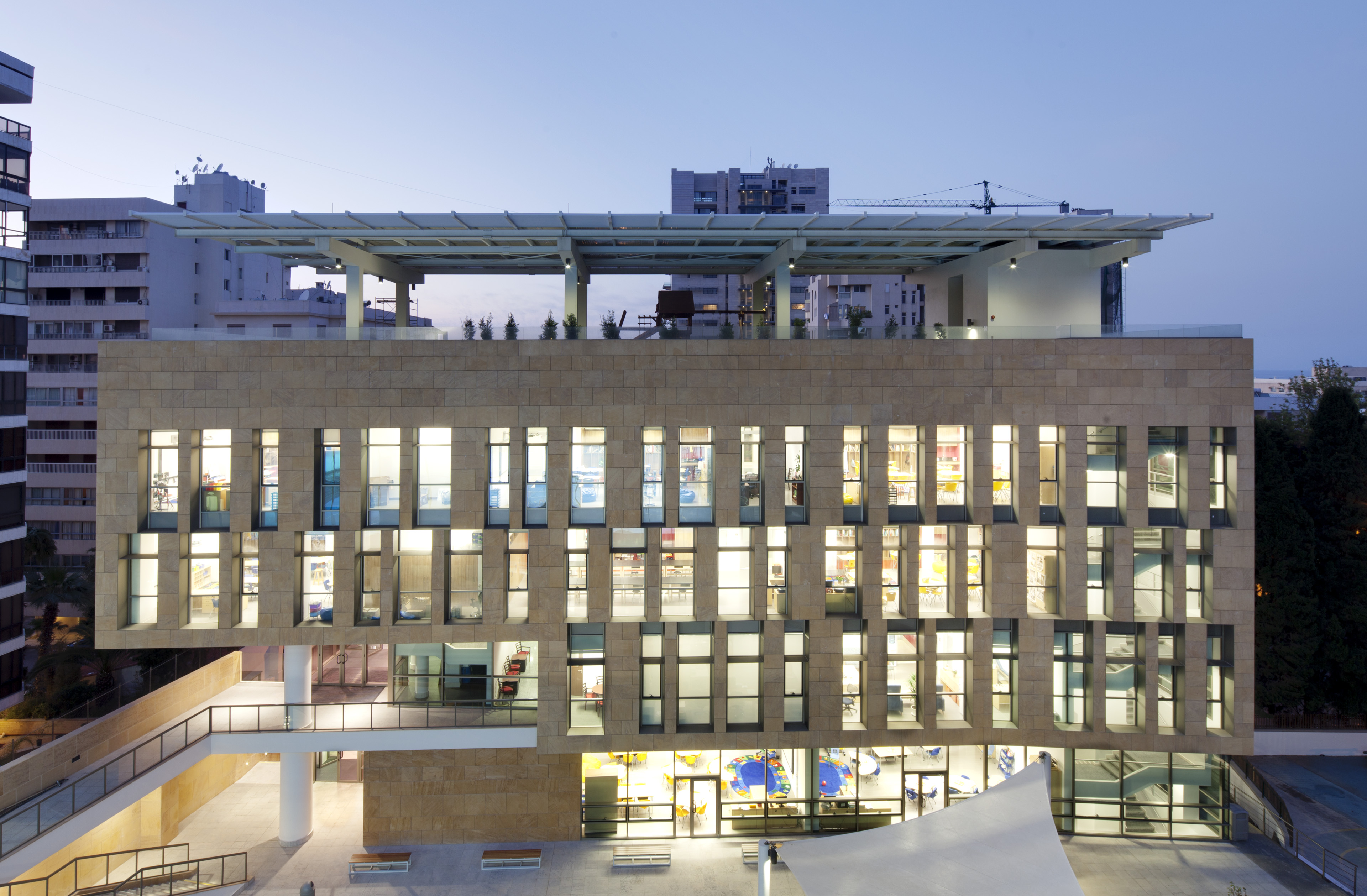 View from exterior of light shining through windows at dusk